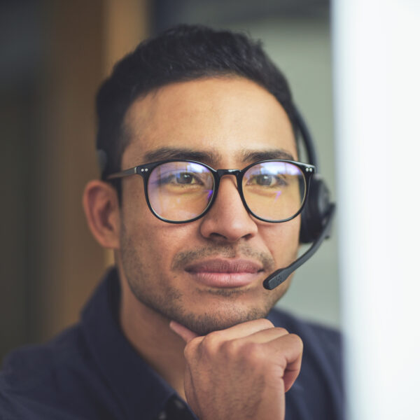 Asian man wearing a microphone/headphone headset.
