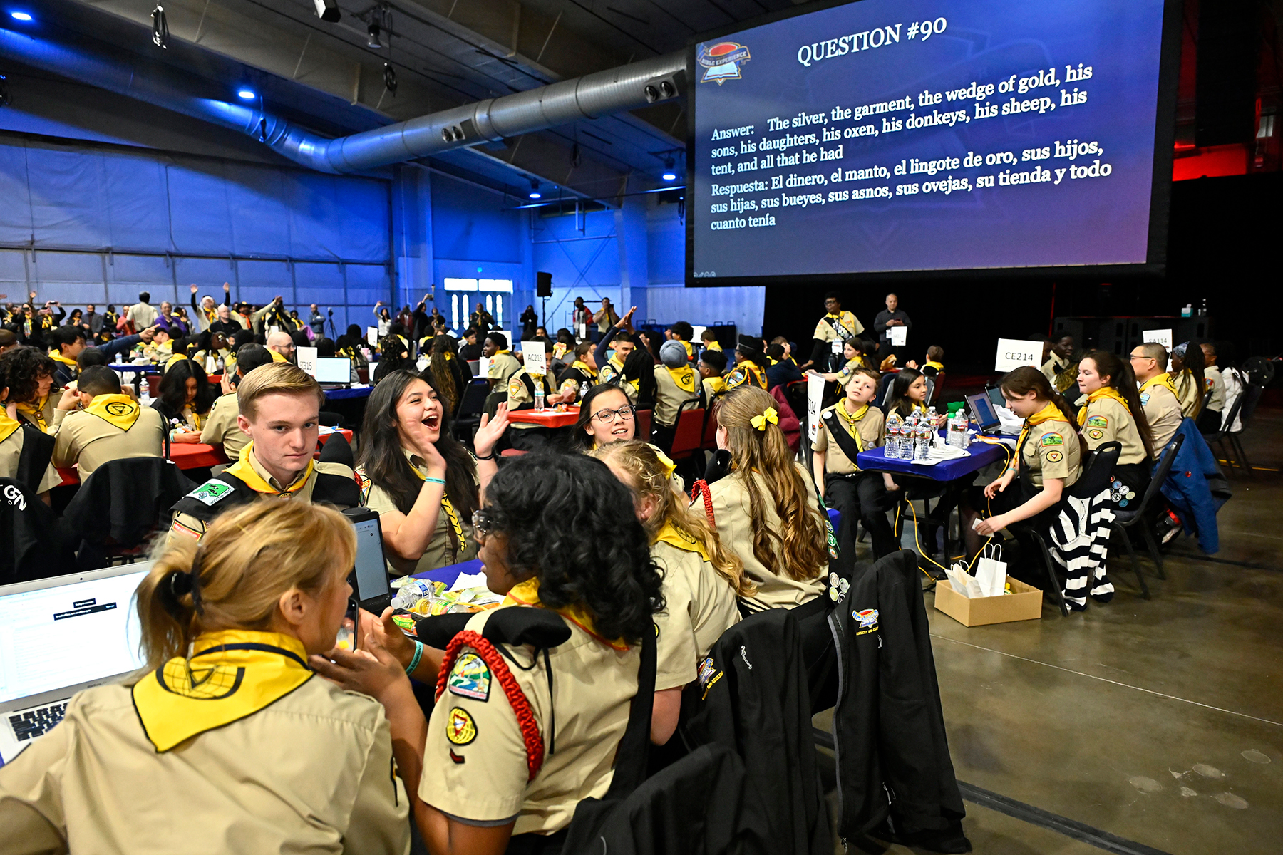 A big screen reading 90, with a question and answer is in the background. Pathfinders at tables are in the foreground.