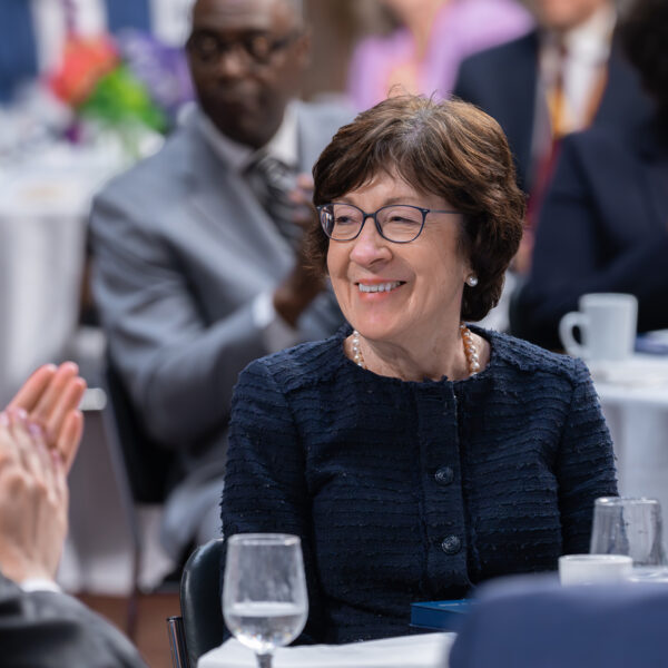 Close-up of a smiling white woman seated at a dinner table