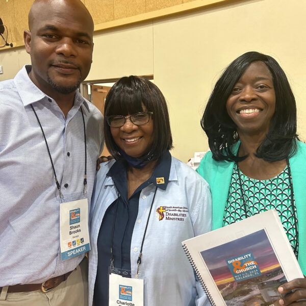 Photo of a black man and two black women dressed in business casual at a conference