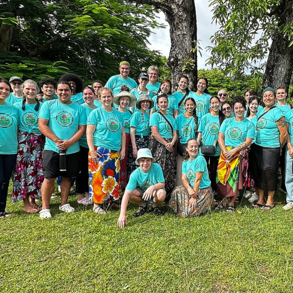 Group photo of people in green t-shirts outside in Fiji