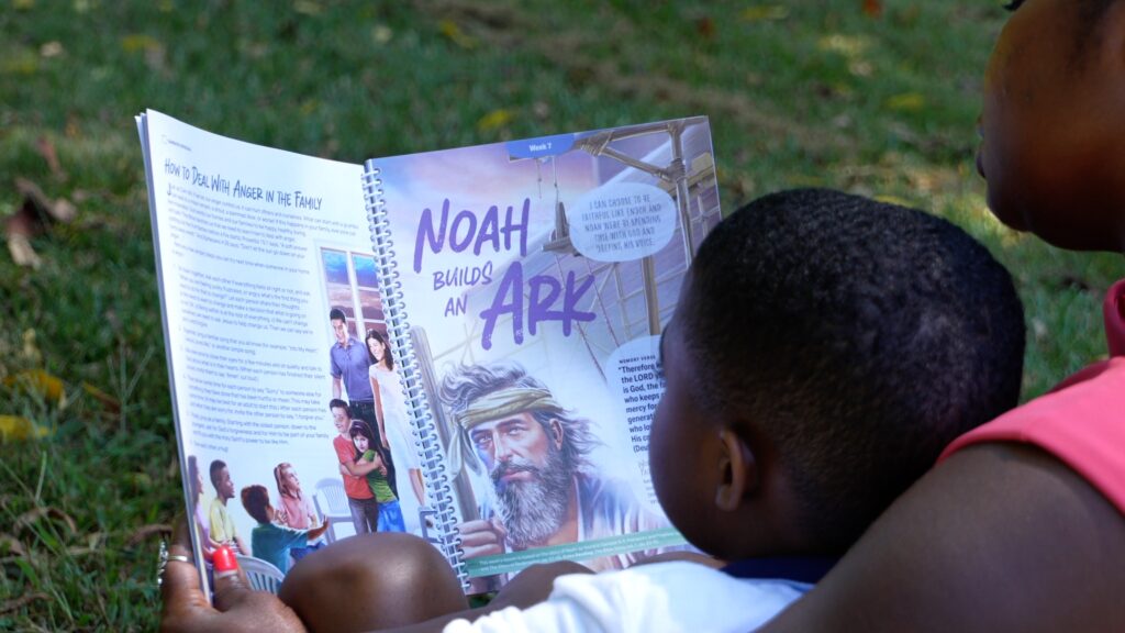 Mother and toddler son reading one of the stories in the new Sabbath School program