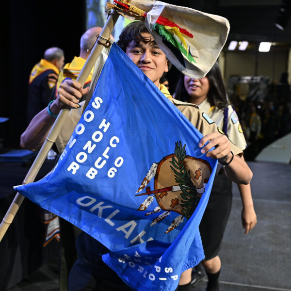 A young Pathfinder holds up a flag representing his club during the awards ceremony