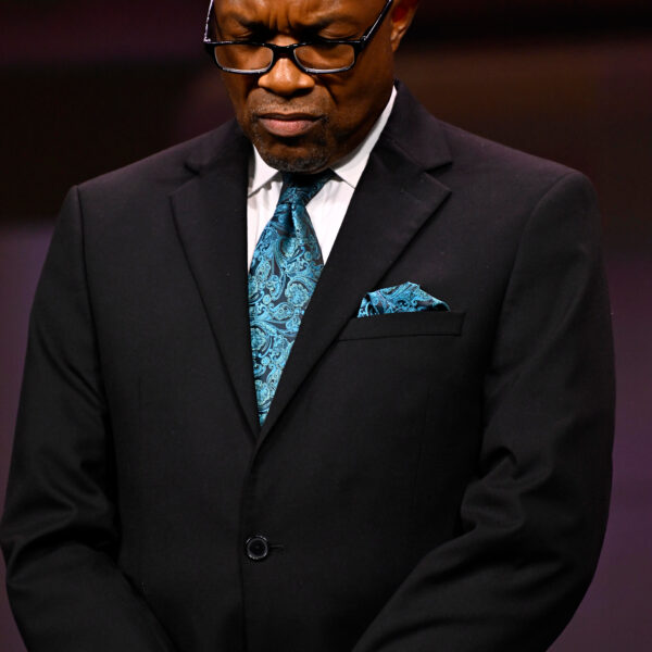 Black man in a suit praying