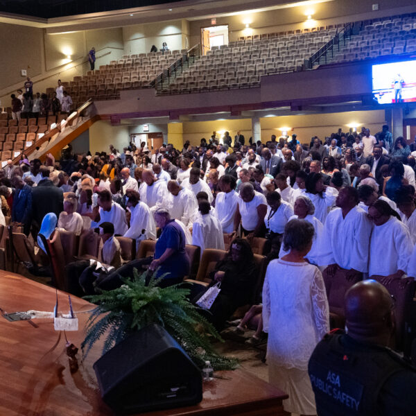 A congregation of people prepare for holy baptism.
