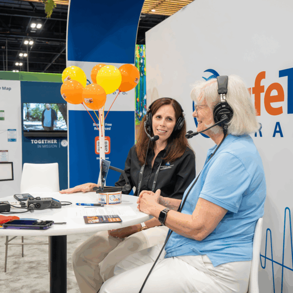 Two women doing a podcast in an exhibit hall