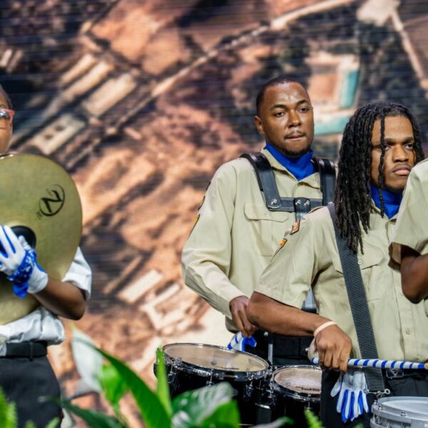 Pathfinders and leaders play drums on the General Conference stage.