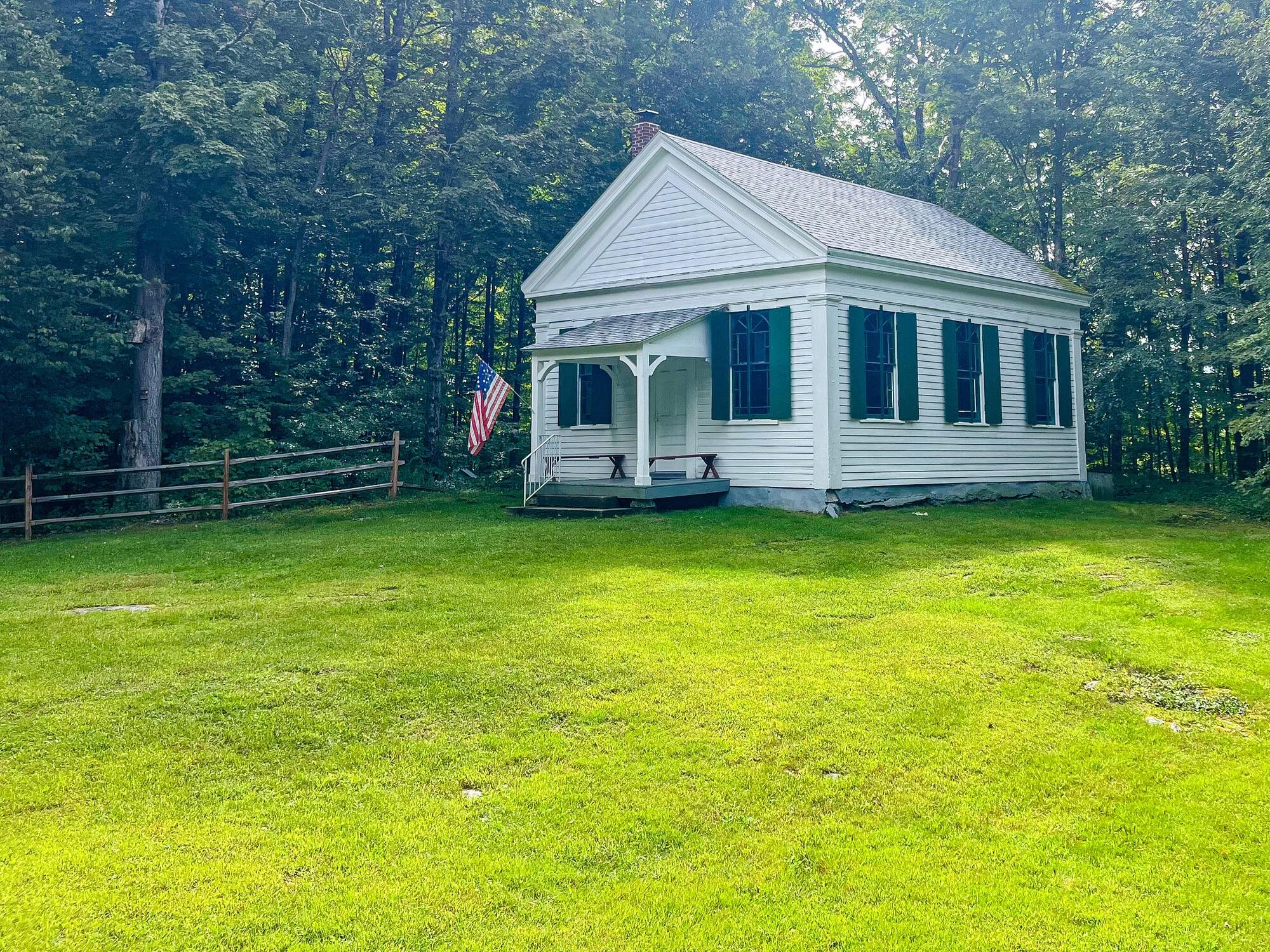 Small white clapboard historic church in a green meadow