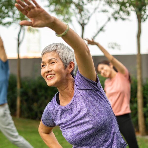 Photo of people doing aerobic exercise as a group outside.