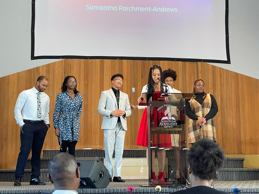 Several young men and women stand on a church stage