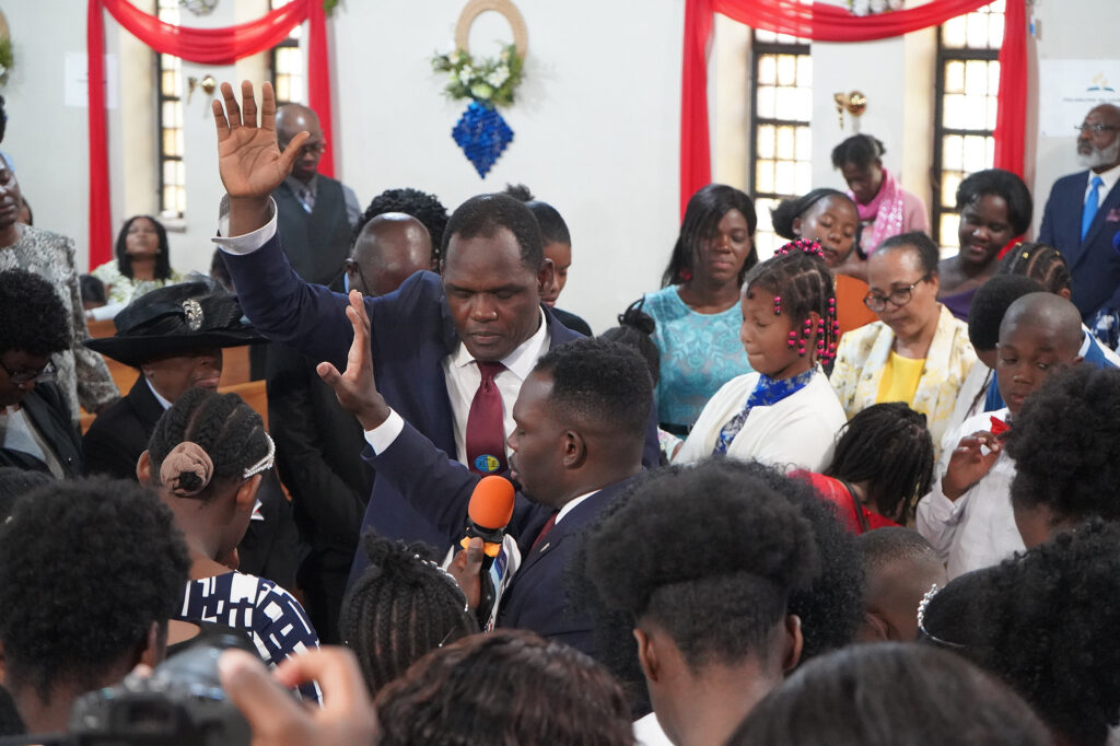 Close-up of several people standing up in a sanctuary
