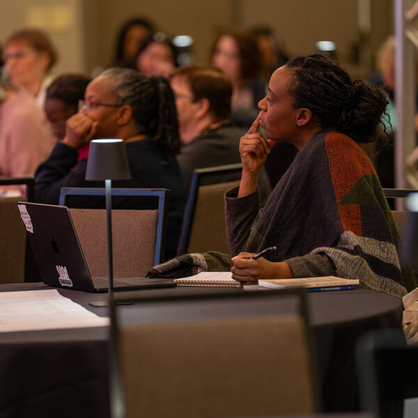 A woman listens carefully in a conference room.