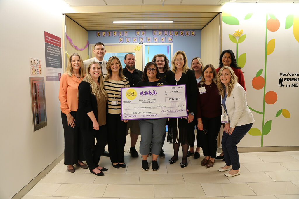 Group of people standing holding a check