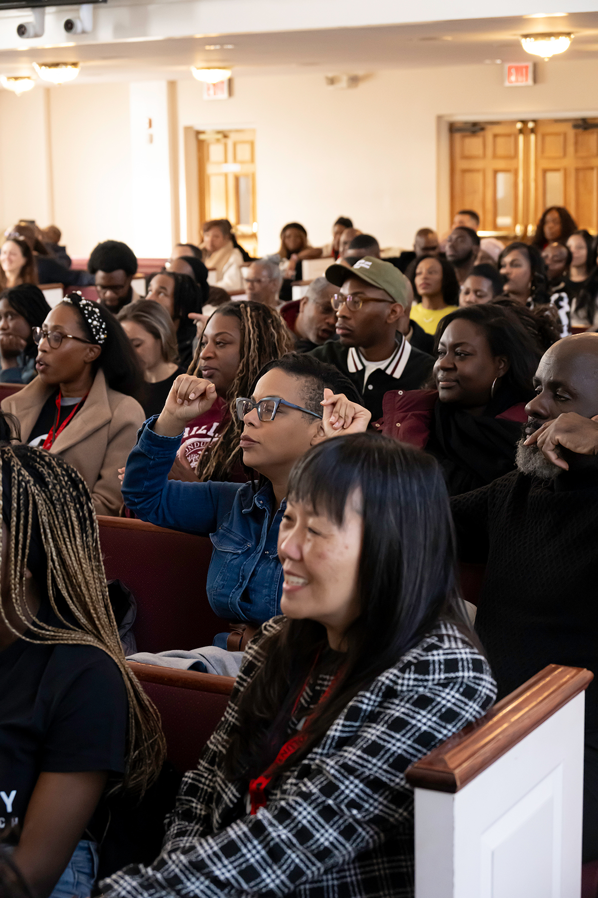 A diverse group of people listen attentively in a full sanctuary