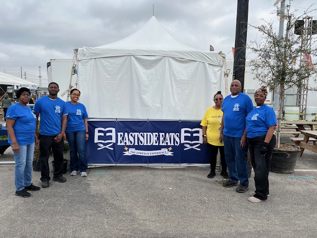 6 individuals (women and men) standing outdoors in front of a white event tent.
