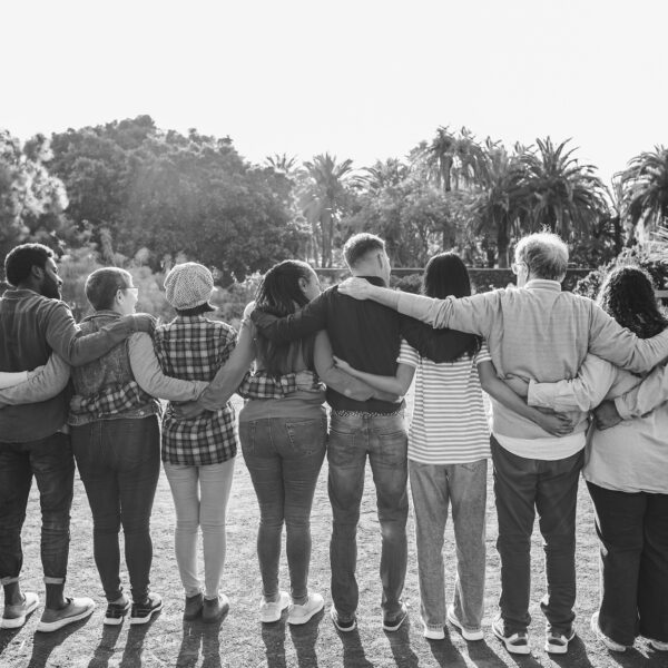 Group of multigenerational people hugging each others - Support, multiracial and diversity concept - Main focus on center people - Black and white editing