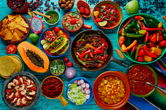 An assortment of Hispanic and Latino foods spread out on a blue wooden table top.