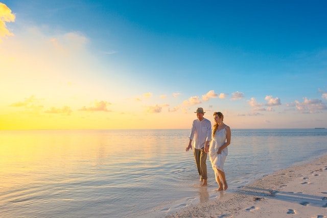 A couple walking on the beach at sunrise