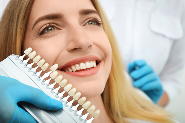 Image of a smiling young woman having a cosmetic dentistry consultation.