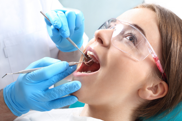 Close up of a young woman getting a dental cleaning from a dentist