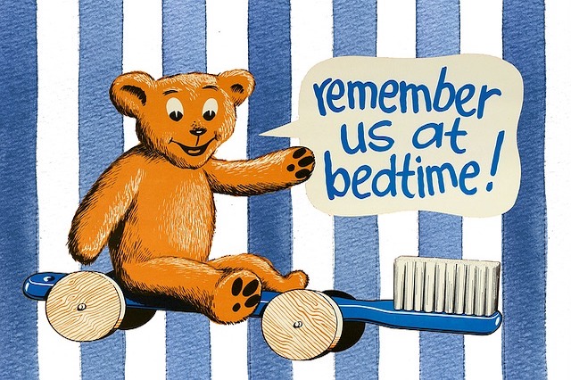 A teddy bear on a toothbrush car saying remember us at bedtime