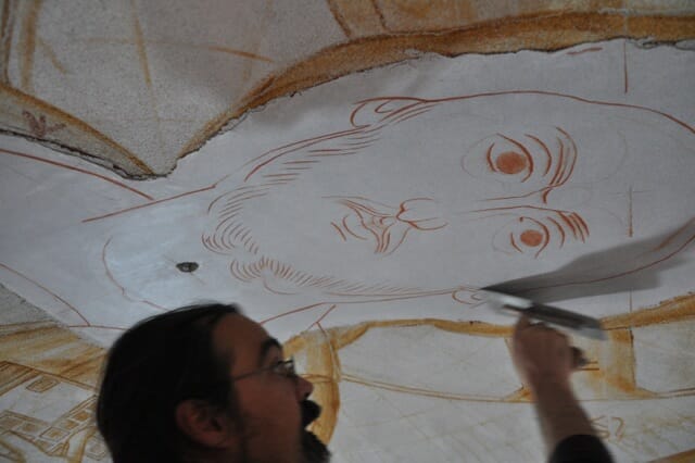 The final sepia drawing takes shape on the wet plaster.