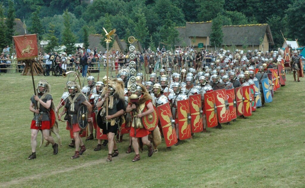Historical reenactors dressed as Roman soldiers bearing vexilla and aquila.