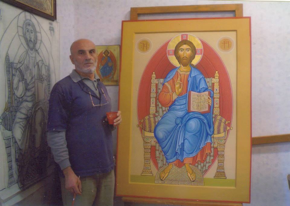 Amiran Goglidze standing next to one of his icons. 