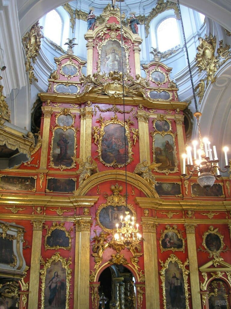 A late-Baroque iconostasis, St. Andrew Cathedral in Ukraine. This screen represents the low-point of iconography, where it has been reduced to small western-style paintings of an almost purely decorative nature. But the screen itself, painted fiery red and gilded, still conveys much of the divine symbolism and liturgical ethos of earlier screens. This goes to show the value of a magnificent screen, and its ability to work wonders for a church, even if the icons it holds are of little merit.