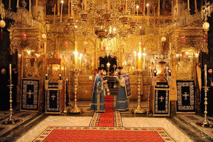 A carved and gilded iconostasis has such presence that it can maintain visual dominance even when crowded behind furniture and lamps. Hilandar, Mt. Athos.