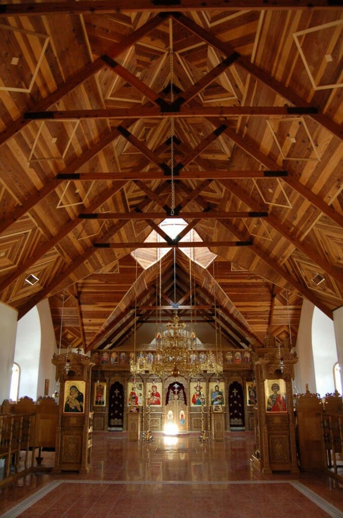 Modern Greek iconostasis at St. Anthony's Monastery, Arizona. The dark carved wood looks dull and indistinct from a distance, and in dim light, so the iconostasis fails to achieve visual dominance. In contrast, the bold parquetry patterns in the wooden ceiling are highly legible, and the are clearly the dominant.