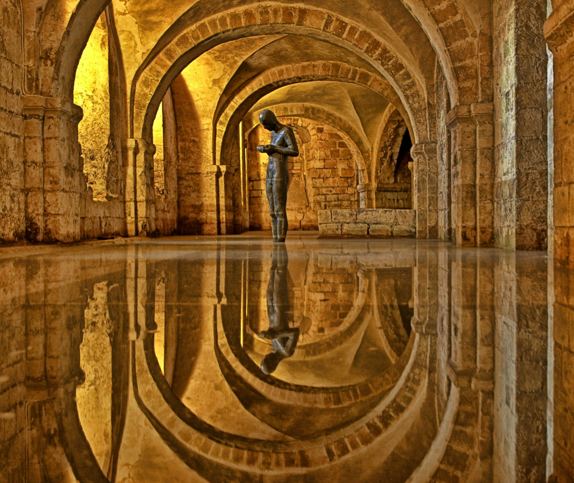 Antony Gormley, Sound II, 1986. Sculpture, metal statue standing in flooded crypt, Winchester Cathedral, England, UK.