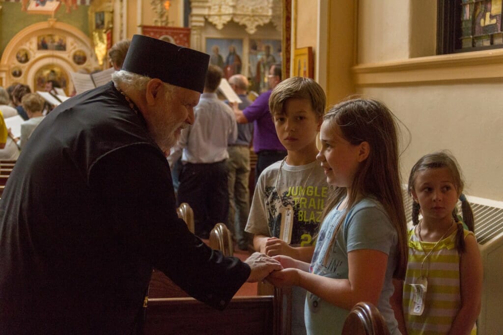 Bishop Paul meeting with some of the children attending St. Mary’s vacation bible school who sang with symposium participants.