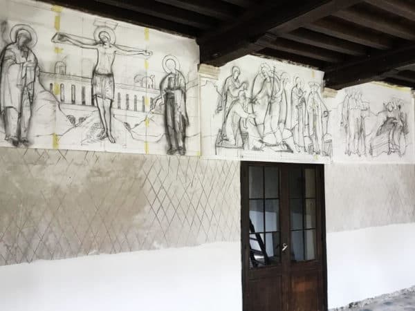 Full-scale charcoal drawings hanging over the doors