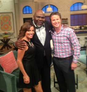 Producer T.D. Jakes (center) joins Kit Hoover (L) and Billy Bush on the set of Access Hollywood Live. 